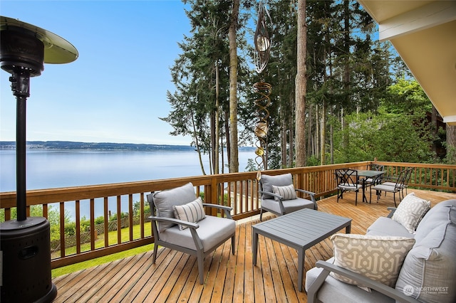 wooden terrace featuring an outdoor living space and a water view