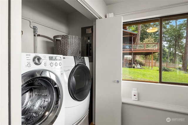 clothes washing area with electric panel and washing machine and dryer