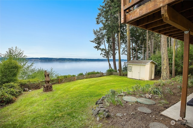 view of yard with a water view and a shed