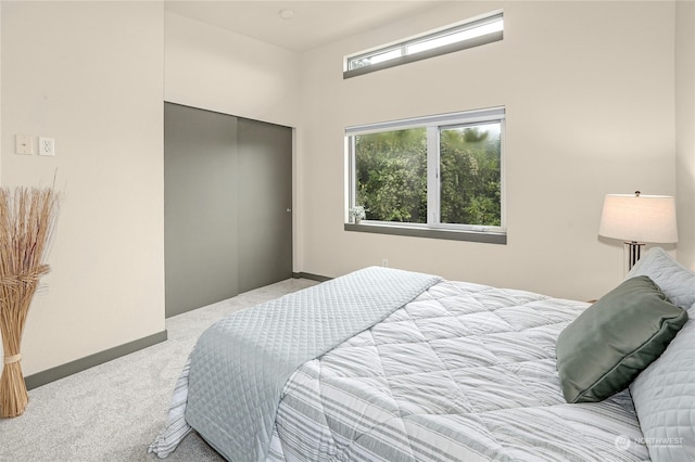 bedroom with light colored carpet and a closet