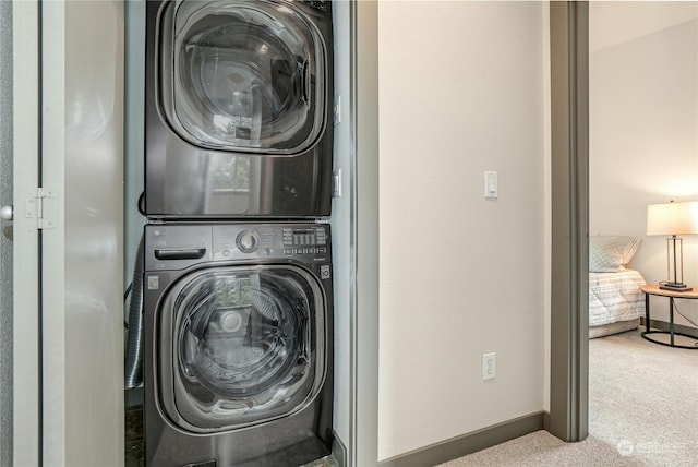 washroom featuring stacked washer / dryer and carpet floors