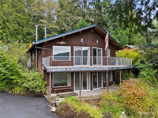 rear view of house featuring a balcony and a patio