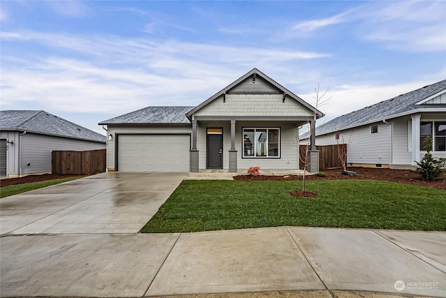 view of front of property with covered porch, a garage, and a front yard