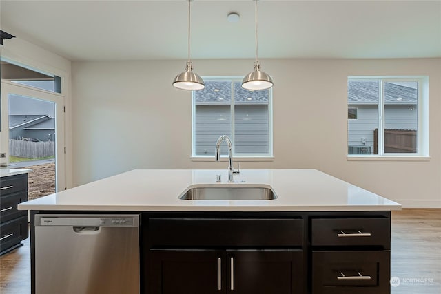 kitchen featuring a center island with sink, stainless steel dishwasher, and plenty of natural light