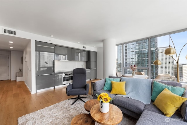 living room featuring floor to ceiling windows and light hardwood / wood-style flooring