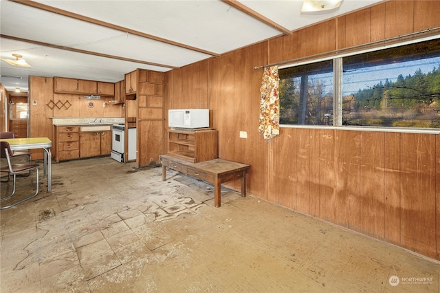 kitchen featuring wood walls and white appliances