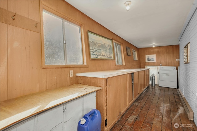 kitchen featuring dark hardwood / wood-style floors, washer / dryer, and wooden walls