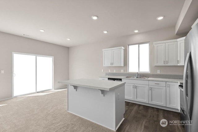 kitchen with white cabinetry, plenty of natural light, sink, and a kitchen island