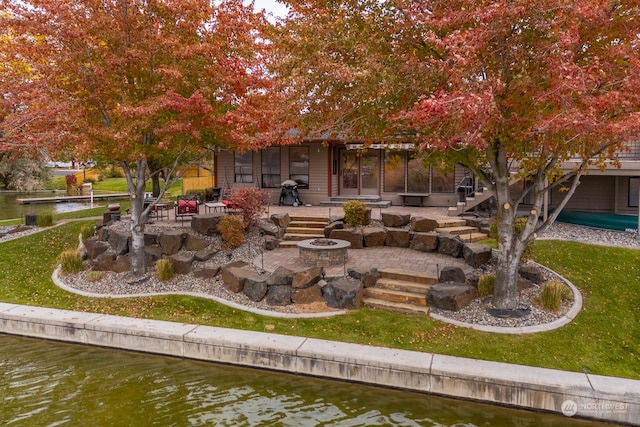 exterior space with a patio area, a yard, and a water view