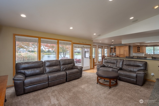 living room with french doors, light colored carpet, and vaulted ceiling