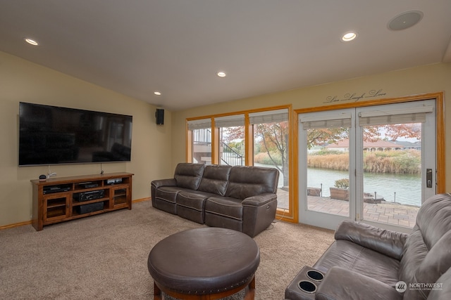 carpeted living room featuring a water view and vaulted ceiling