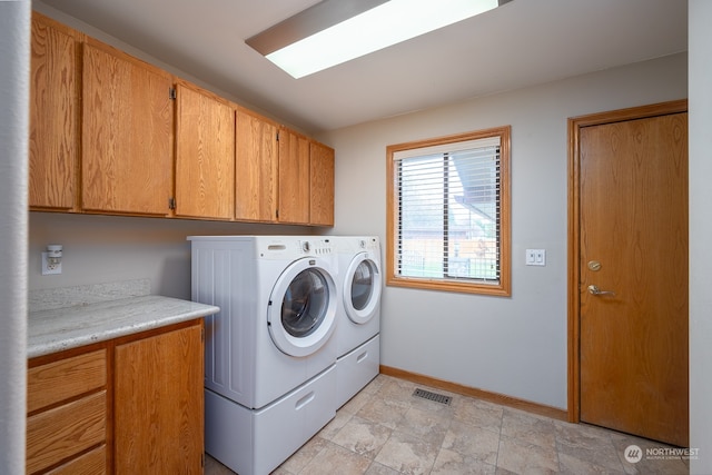 washroom featuring separate washer and dryer and cabinets