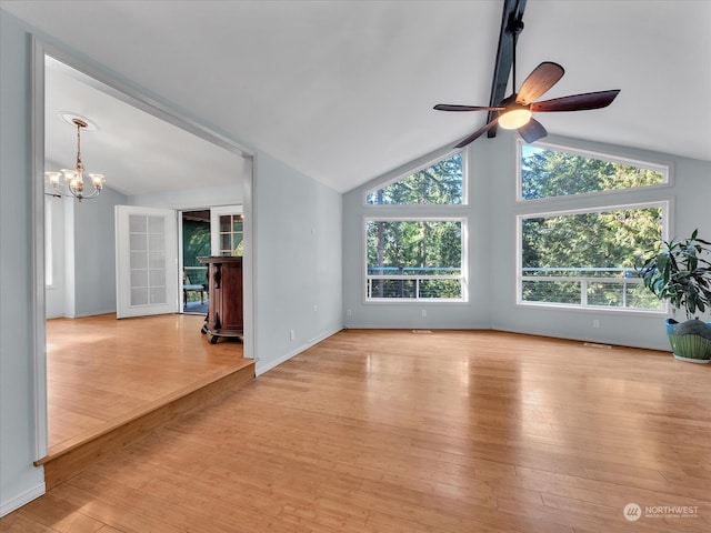 unfurnished living room with light hardwood / wood-style floors, lofted ceiling, and ceiling fan with notable chandelier