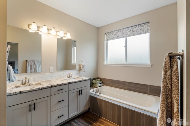 bathroom featuring vanity, hardwood / wood-style floors, and tiled tub