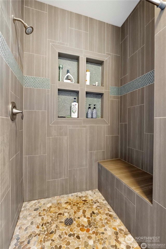 bathroom featuring tile walls and tiled shower