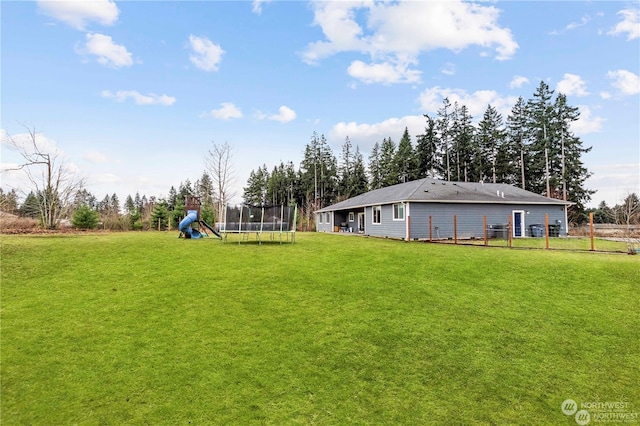 view of yard featuring a trampoline and a playground