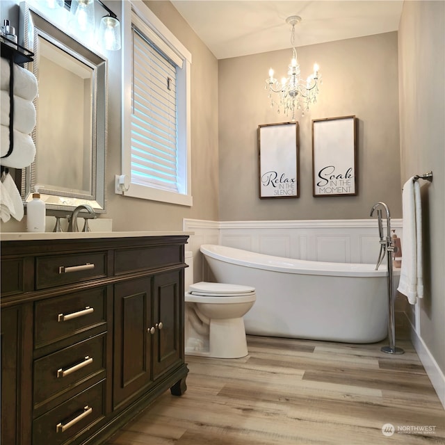 bathroom with a bathtub, toilet, wood-type flooring, and vanity