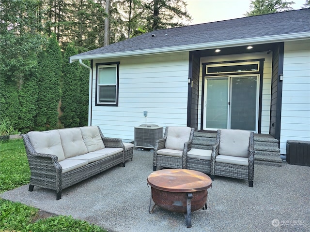 view of patio / terrace featuring central air condition unit and an outdoor living space with a fire pit