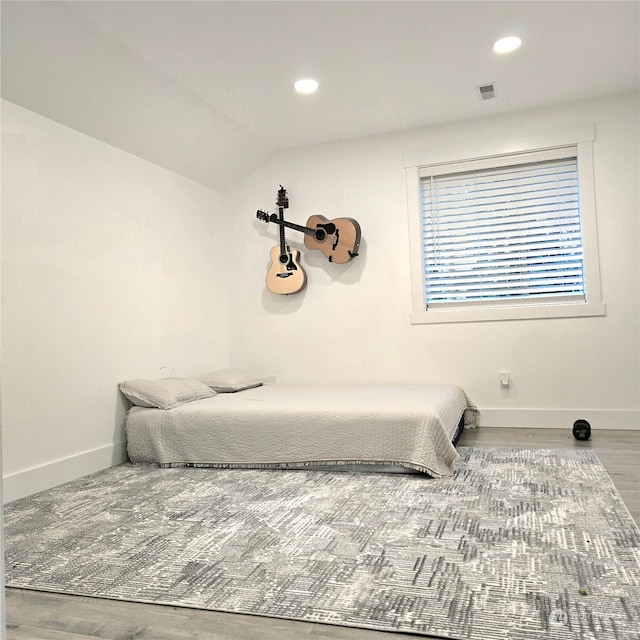 bedroom with lofted ceiling and hardwood / wood-style floors