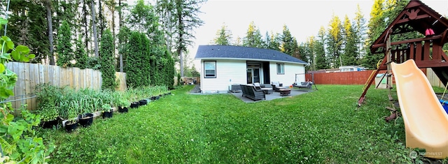 back of house with a patio, an outdoor hangout area, a lawn, and a playground