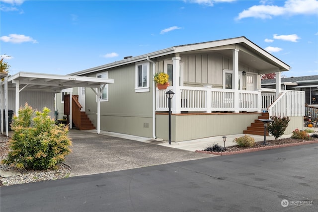 manufactured / mobile home featuring covered porch and a carport