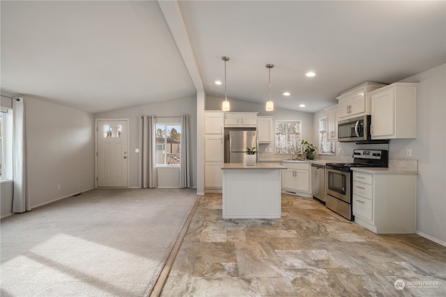 kitchen with vaulted ceiling with beams, a center island, decorative light fixtures, white cabinetry, and appliances with stainless steel finishes