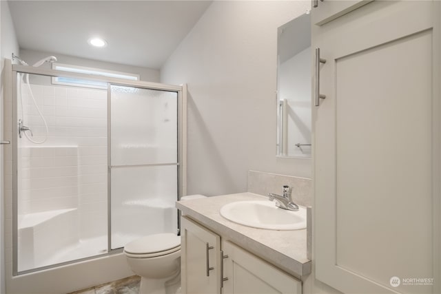 bathroom with vanity, a shower with shower door, and toilet