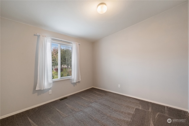 empty room featuring dark carpet