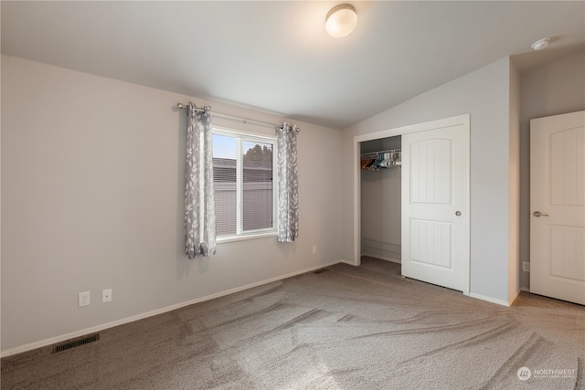 unfurnished bedroom featuring a closet, carpet, and lofted ceiling