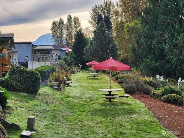 yard at dusk with a deck with mountain view