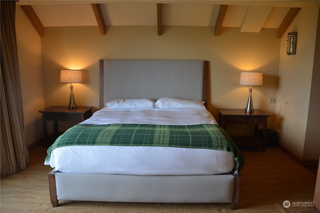 carpeted bedroom featuring beamed ceiling