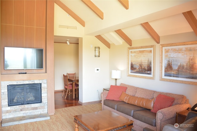 living room with hardwood / wood-style floors, vaulted ceiling with beams, and a fireplace