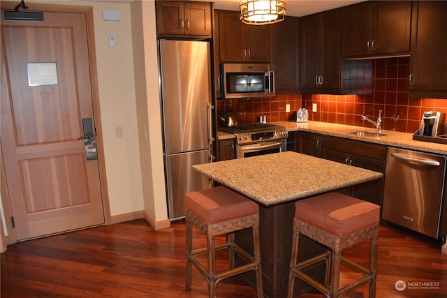 kitchen featuring light stone countertops, tasteful backsplash, appliances with stainless steel finishes, and dark hardwood / wood-style flooring