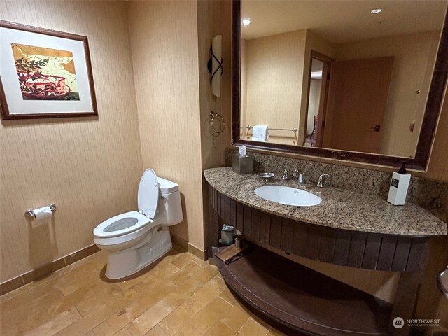 bathroom with vanity, toilet, and hardwood / wood-style flooring