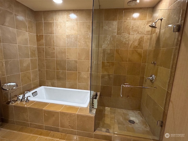 bathroom featuring shower with separate bathtub, tile walls, and tile patterned flooring