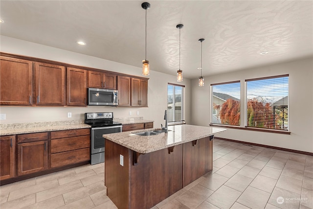 kitchen with appliances with stainless steel finishes, light stone counters, sink, decorative light fixtures, and a breakfast bar area