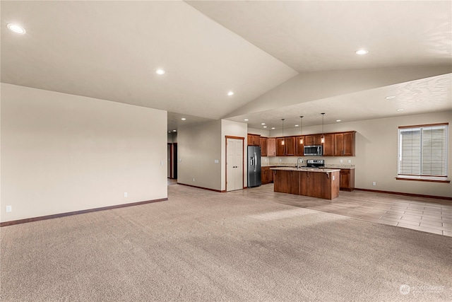 kitchen featuring stainless steel appliances, decorative light fixtures, vaulted ceiling, light carpet, and a kitchen island