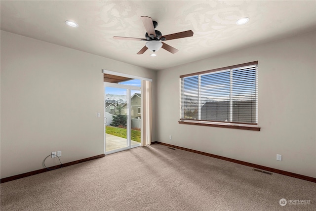 carpeted empty room featuring ceiling fan and a healthy amount of sunlight