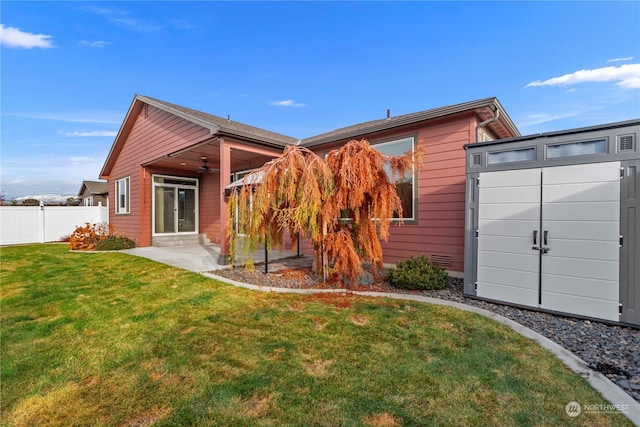 rear view of property with a yard and ceiling fan