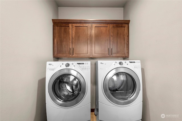 washroom with washer and clothes dryer and cabinets