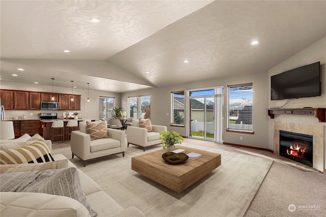 living room with lofted ceiling, a fireplace, and light carpet