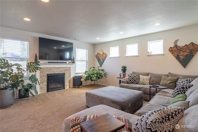 living room with carpet floors, a tiled fireplace, and plenty of natural light