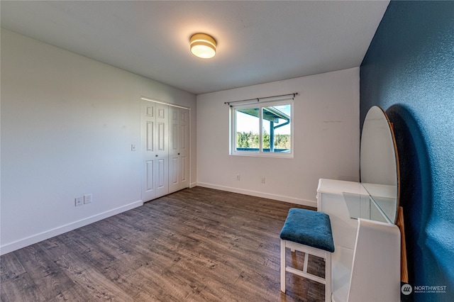 unfurnished bedroom with dark wood-type flooring and a closet