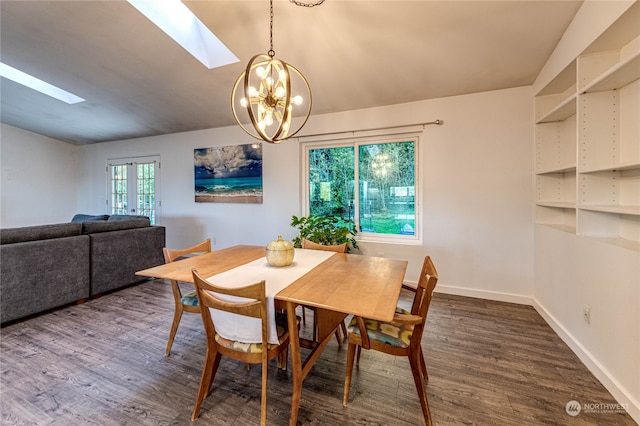 dining room featuring vaulted ceiling with skylight, a chandelier, and dark hardwood / wood-style floors