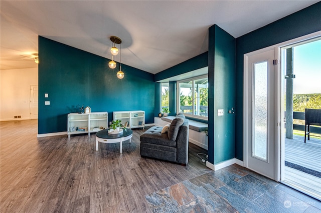 living area with wood-type flooring and ceiling fan