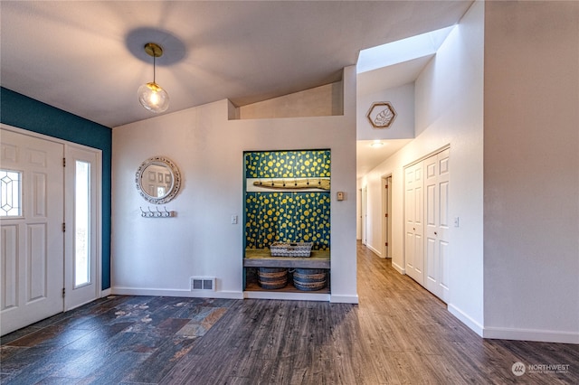 foyer with vaulted ceiling and dark hardwood / wood-style flooring