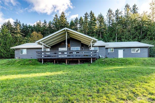 rear view of property with a deck and a lawn