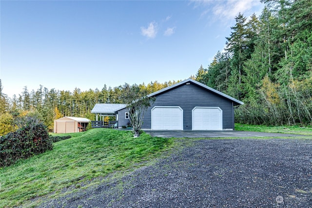 ranch-style home with a front yard, a garage, and an outbuilding