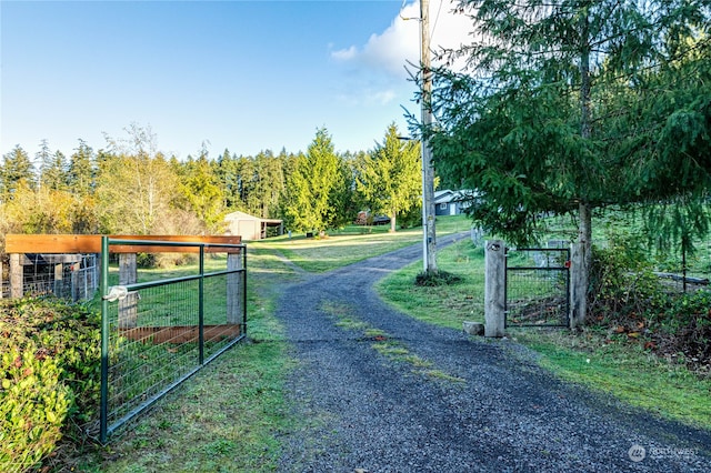 view of gate with a yard