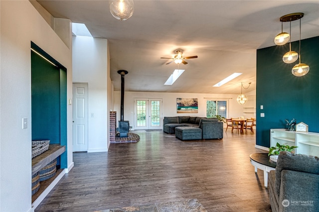 living room featuring vaulted ceiling, dark hardwood / wood-style floors, a wood stove, and ceiling fan